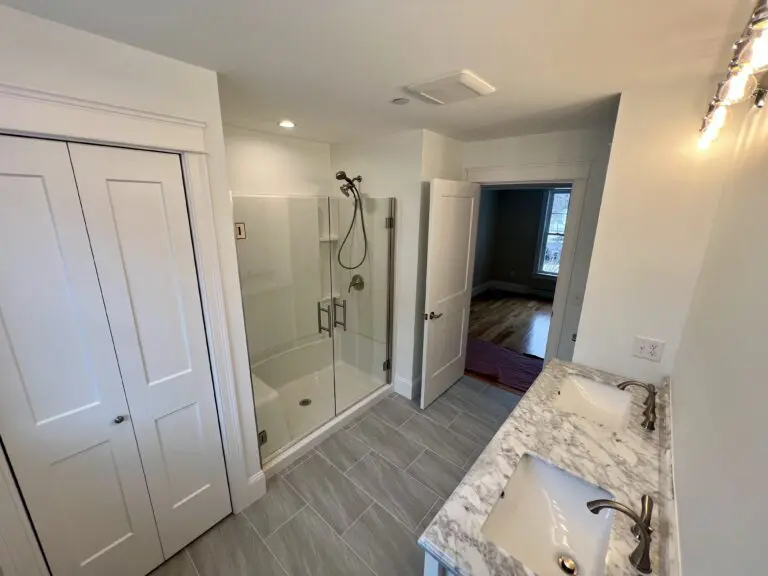 Modern bathroom with shower and double sinks.