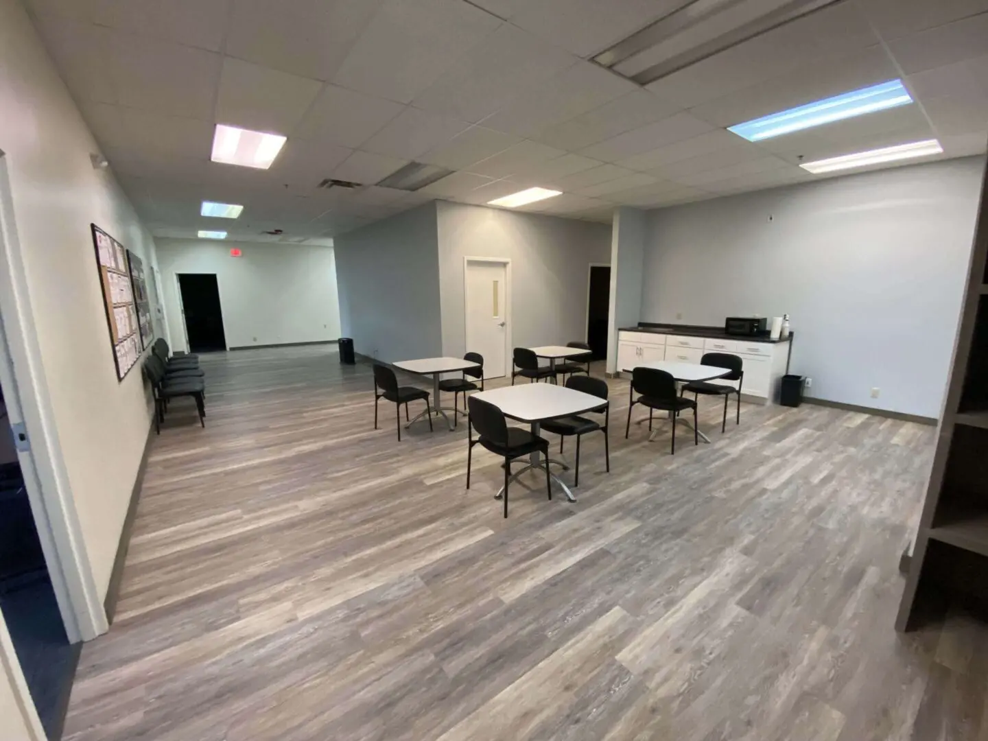 Spacious break room with tables and chairs.