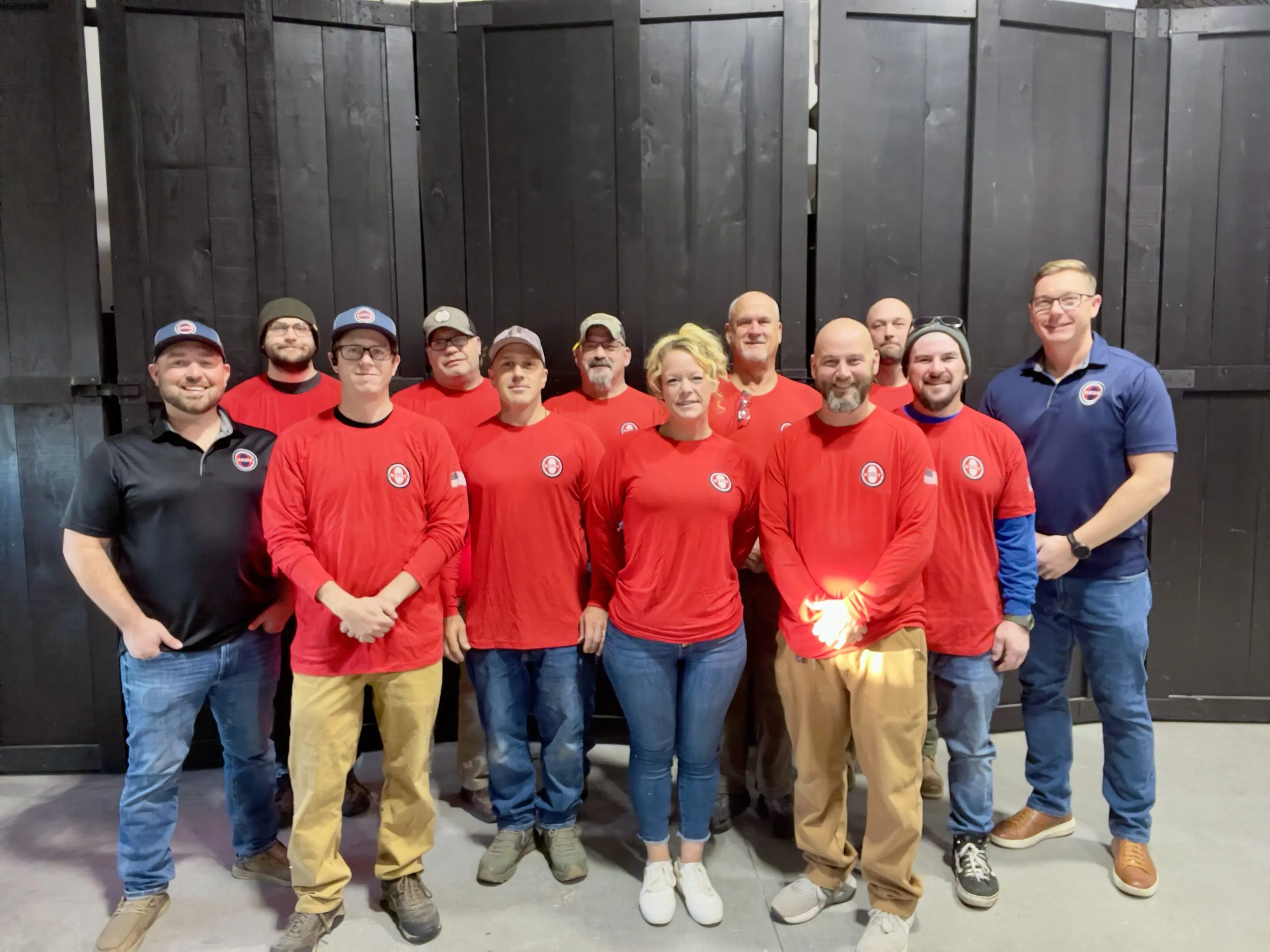 Group of people wearing red shirts, smiling.