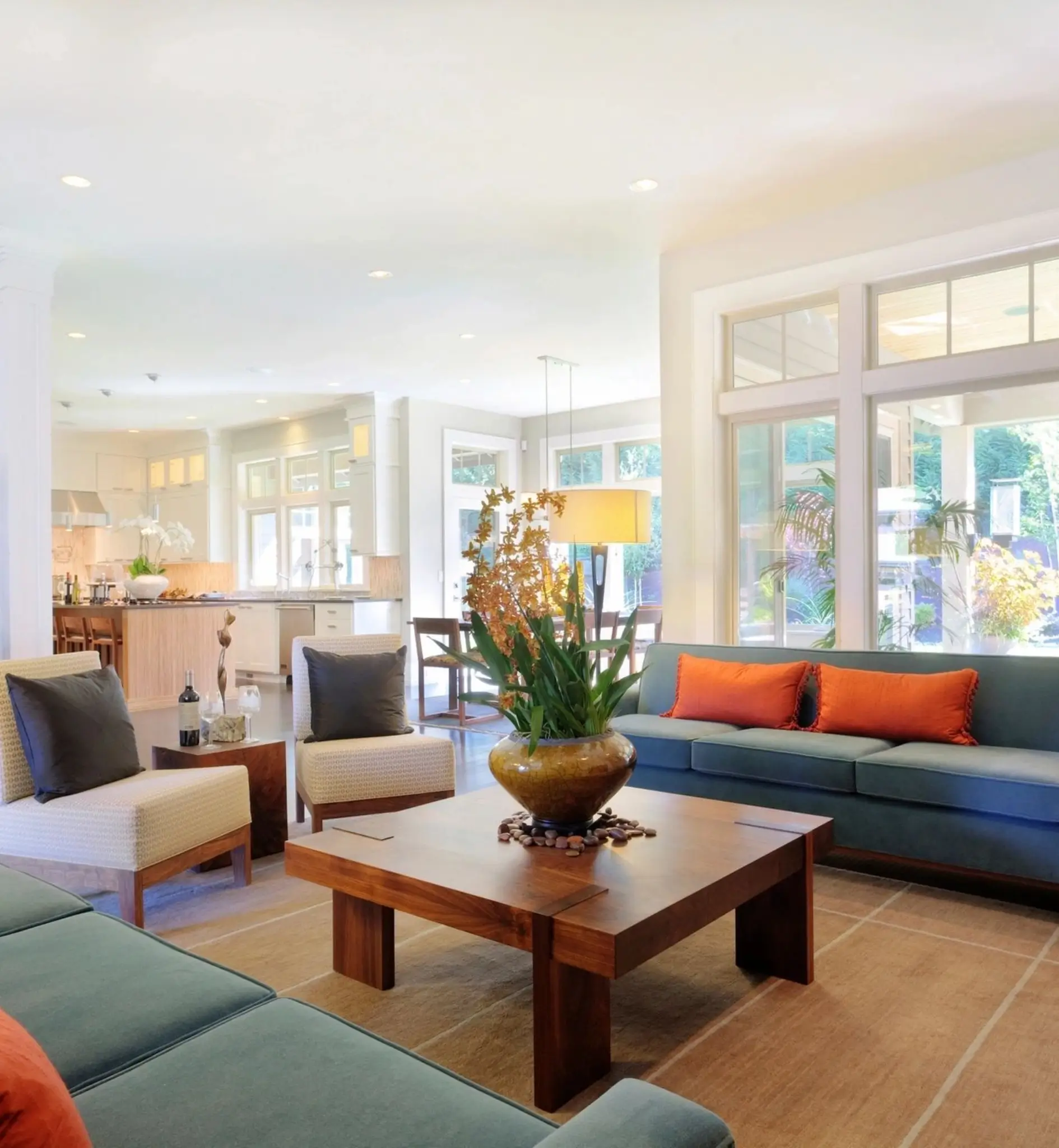 Modern living room with large windows, seating.