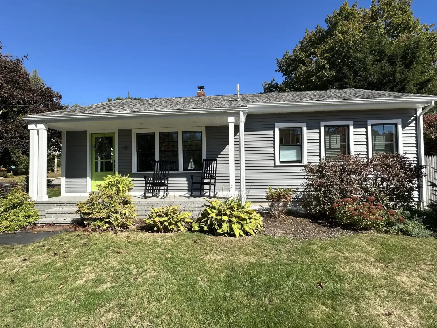 Gray house with green door, front porch.