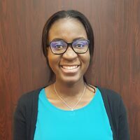 Smiling woman wearing glasses and a necklace.